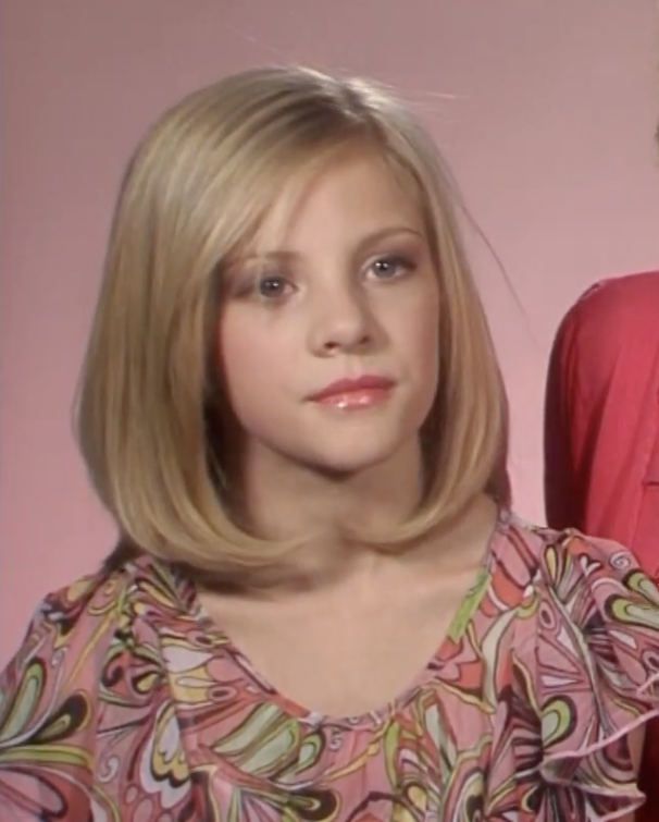 A young Paige in front of a pink backdrop