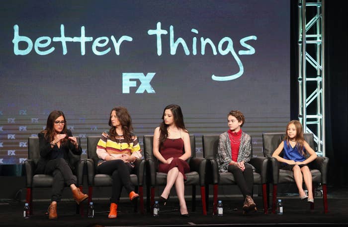 The cast of Better Things sit on a stage while Pamela Adlon, creator and star, speaks