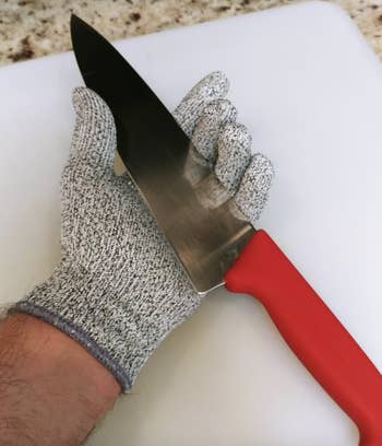A customer review photo of them holding a knife while wearing the gloves
