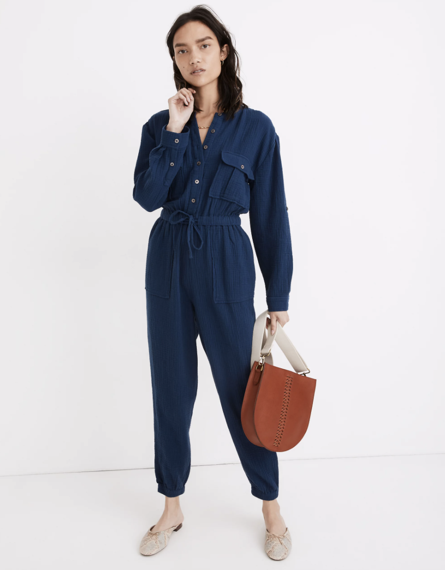 model in a blue long sleeve jumpsuit with a tie at the waist