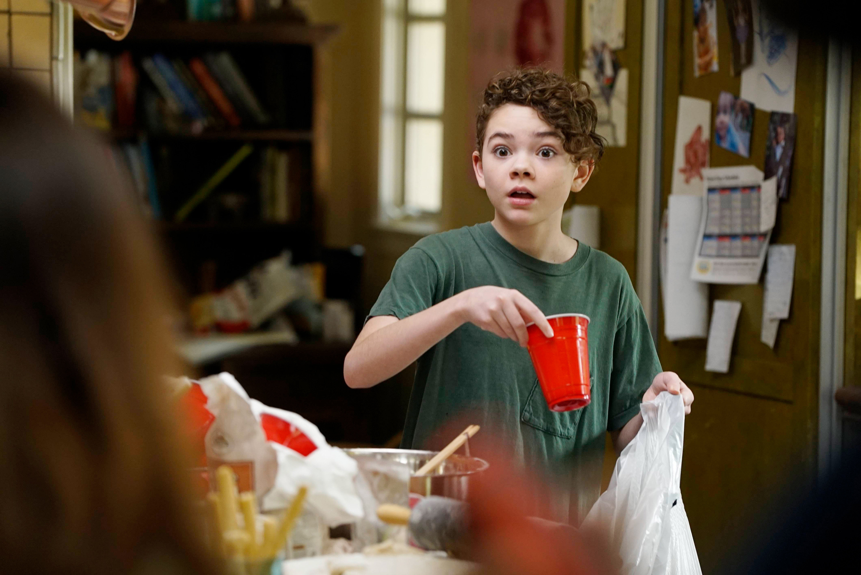 Frankie holds a red plastic cup that he&#x27;s ready to throw in a garbage bag