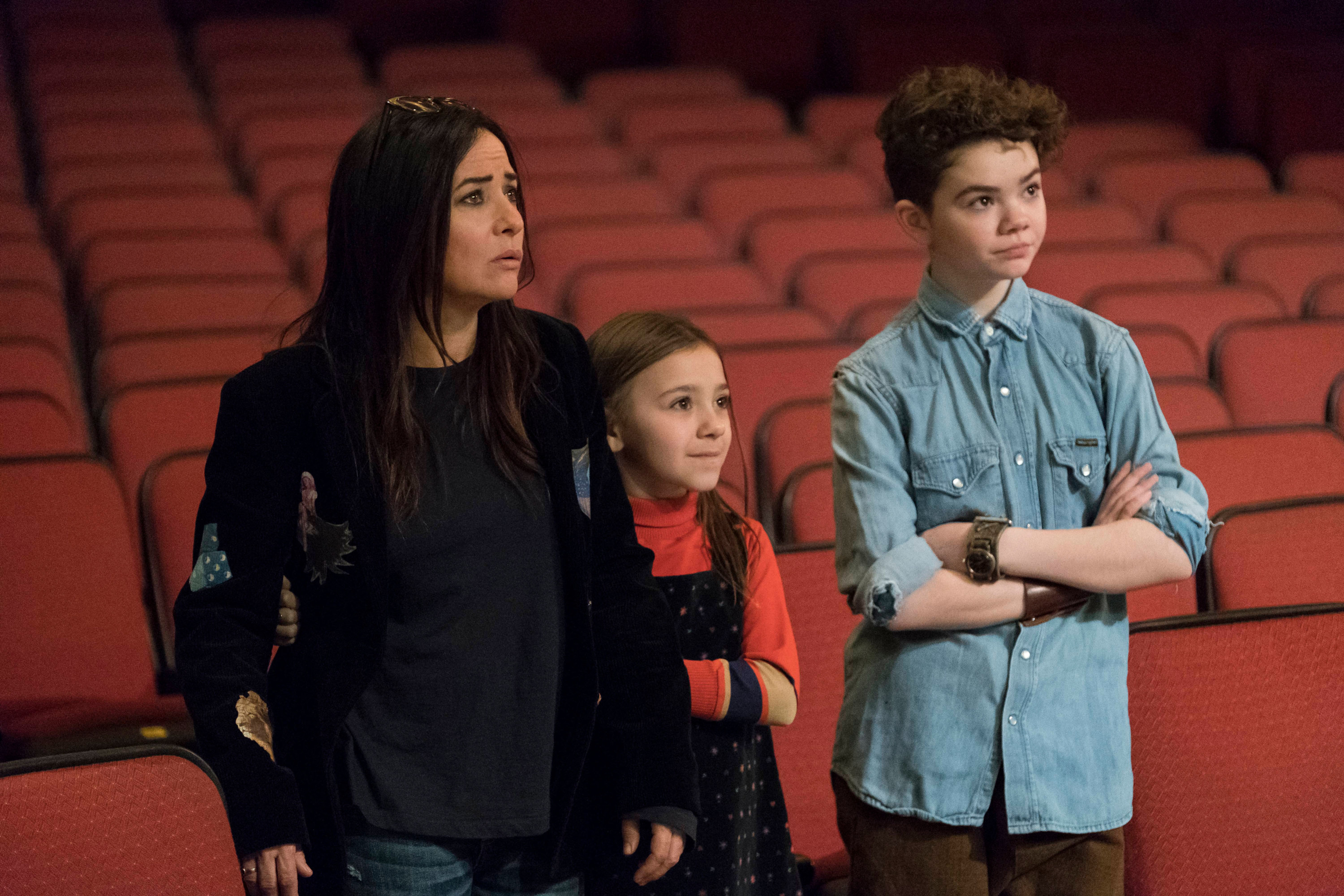 Sam, Duke and Frankie stand in the empty audience and look toward a stage