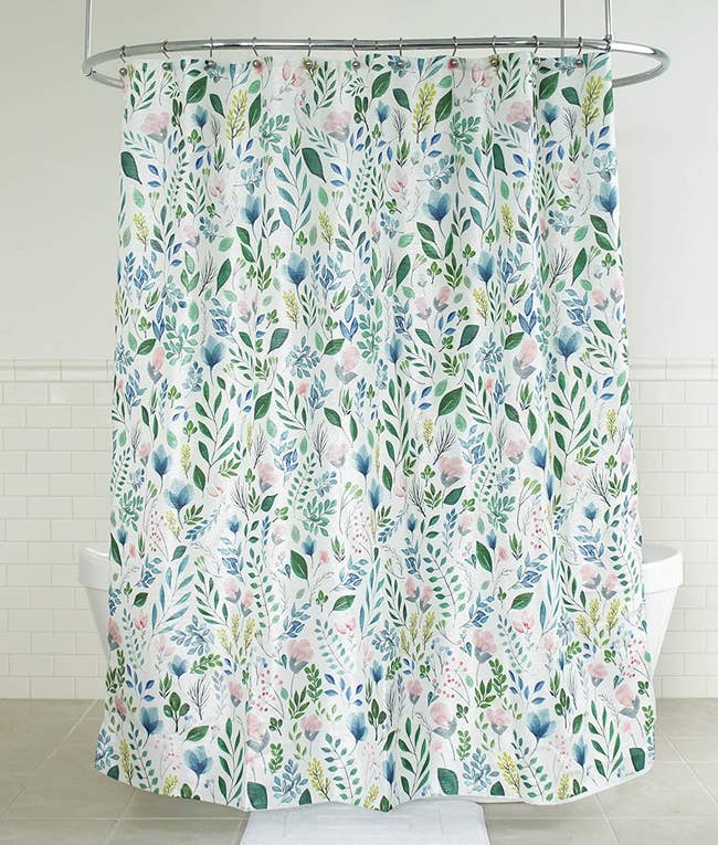 the shower curtain covered in flower and leaf illustrations