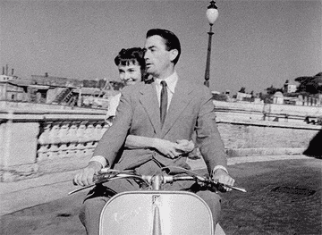 gif of audrey hepburn and gregory peck riding a vespa in rome from &quot;roman holiday&quot;