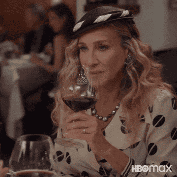 Carrie sipping a glass of wine in a restaurant