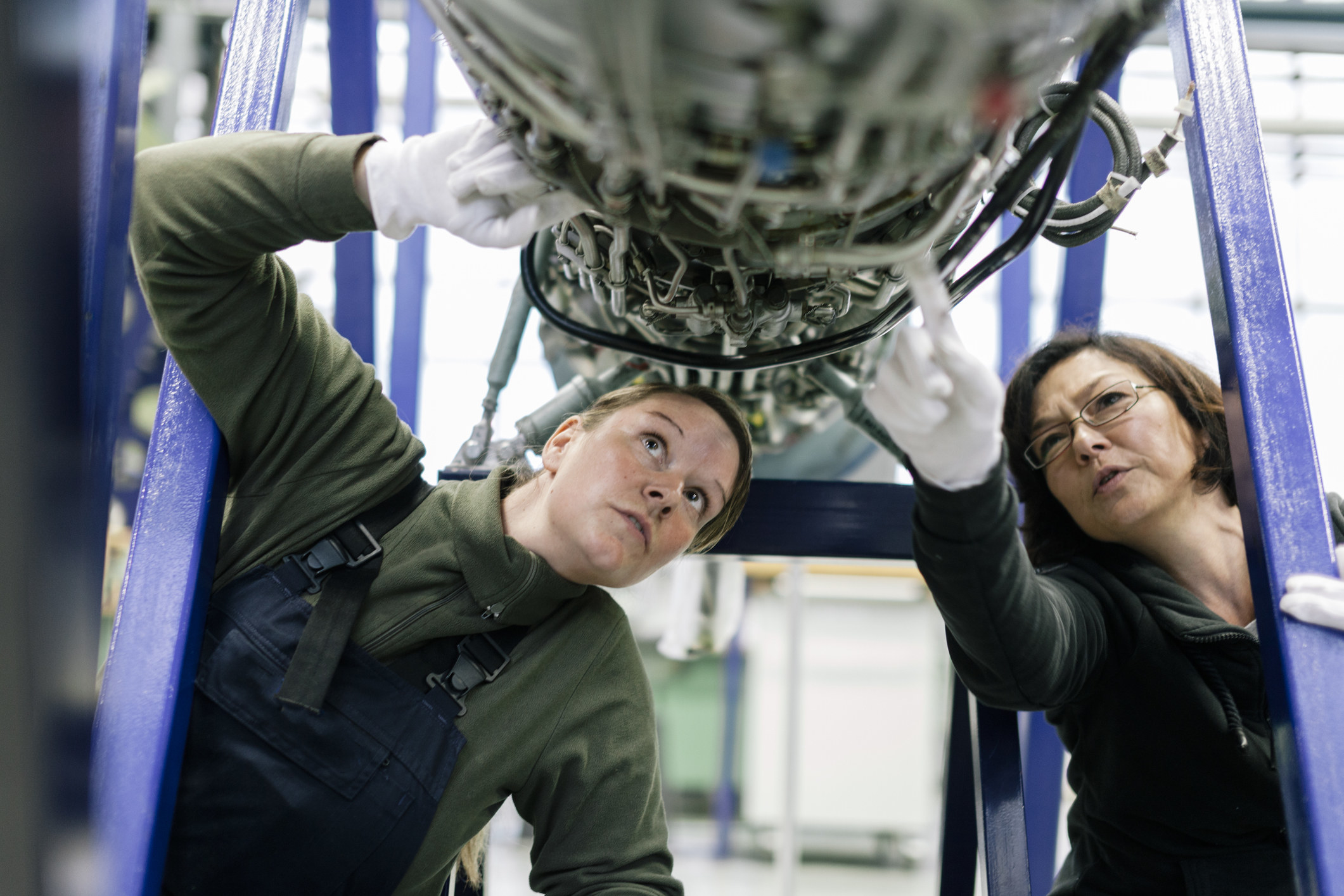 Two women engineers working on a machine