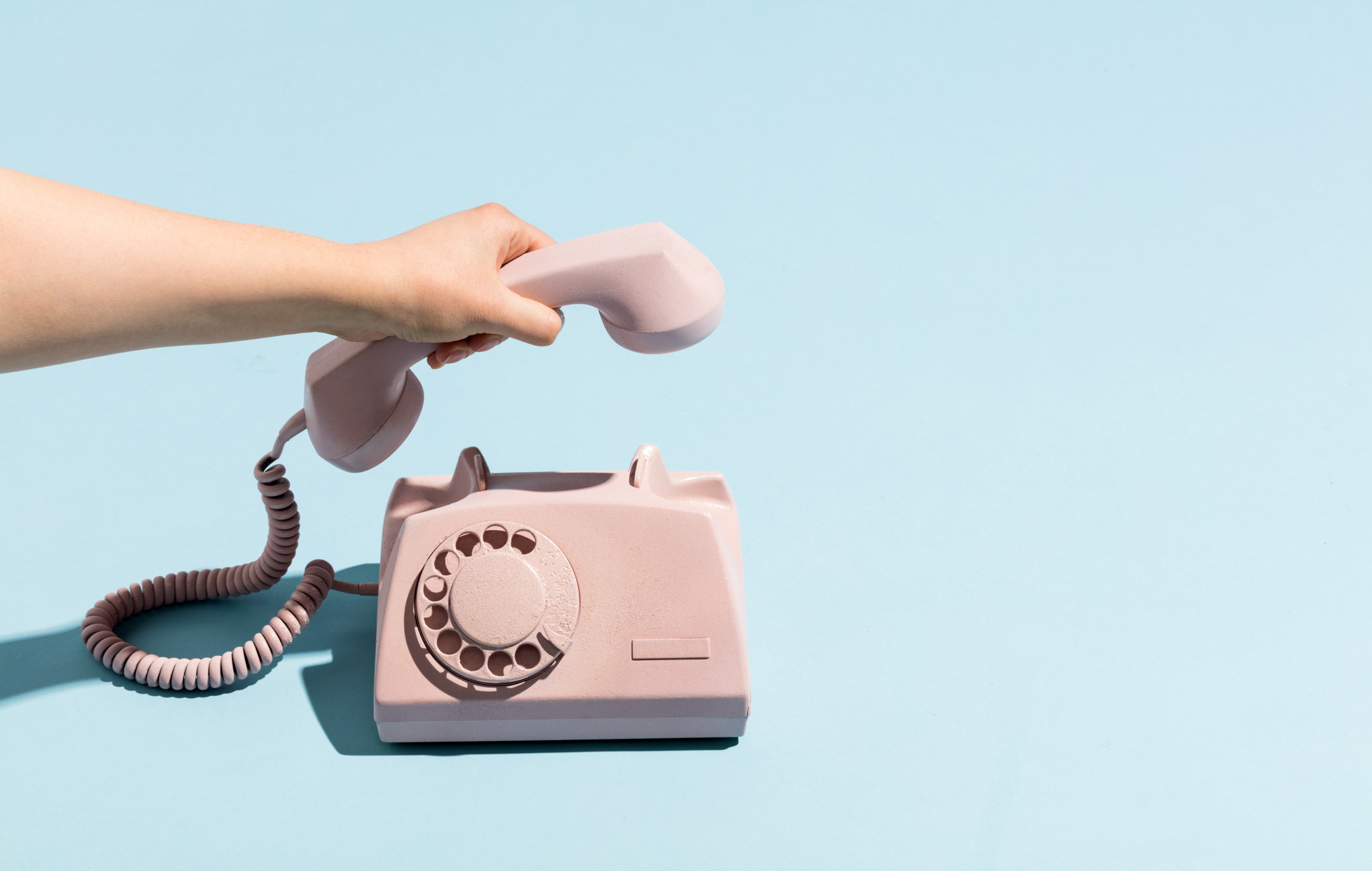 Woman&#x27;s hand putting a retro telephone reciever down, hanging up