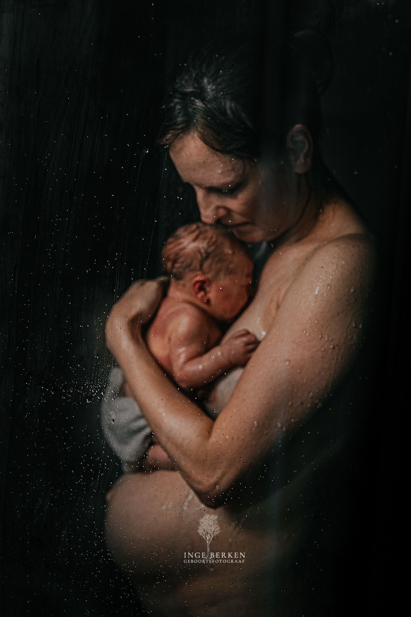 A woman and her new baby stand in the shower