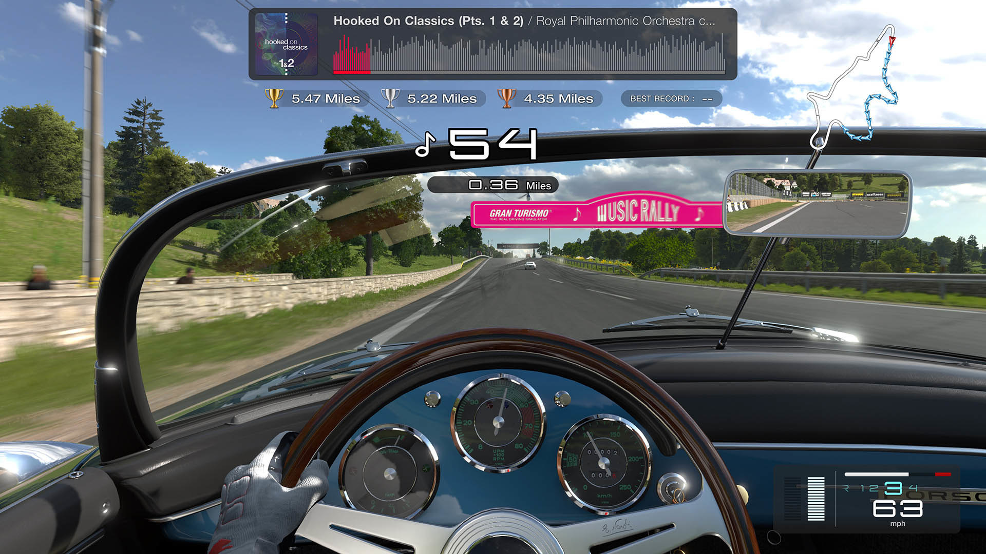 The cockpit view of a race car wheel as the driver races to the beats in a country set race track at noon