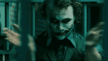 Heath Ledger&#x27;s Joker sits clapping in a prison cell