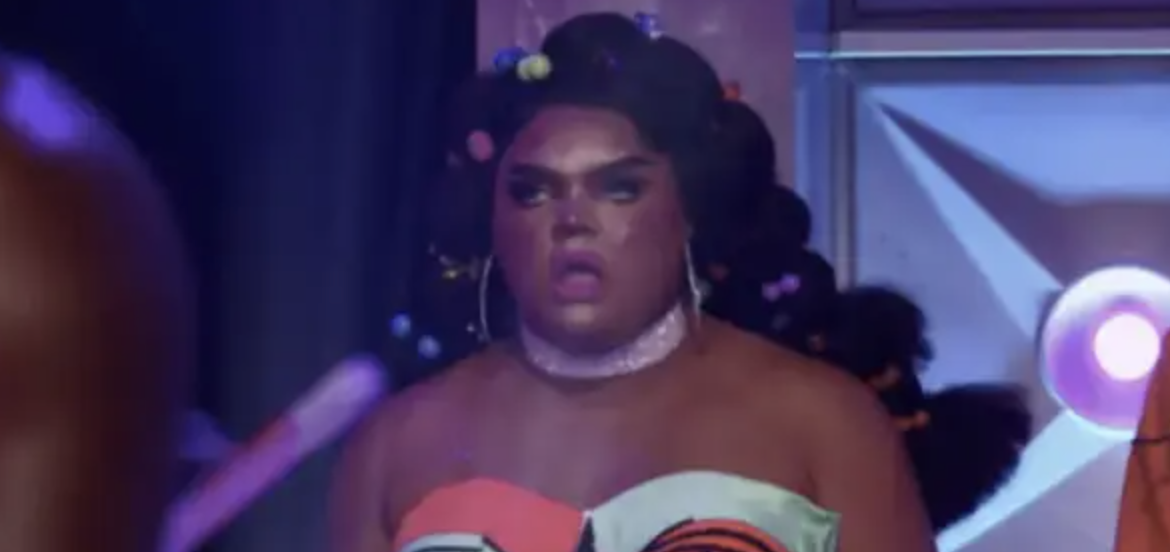 a drag queen with her mouth open in shock