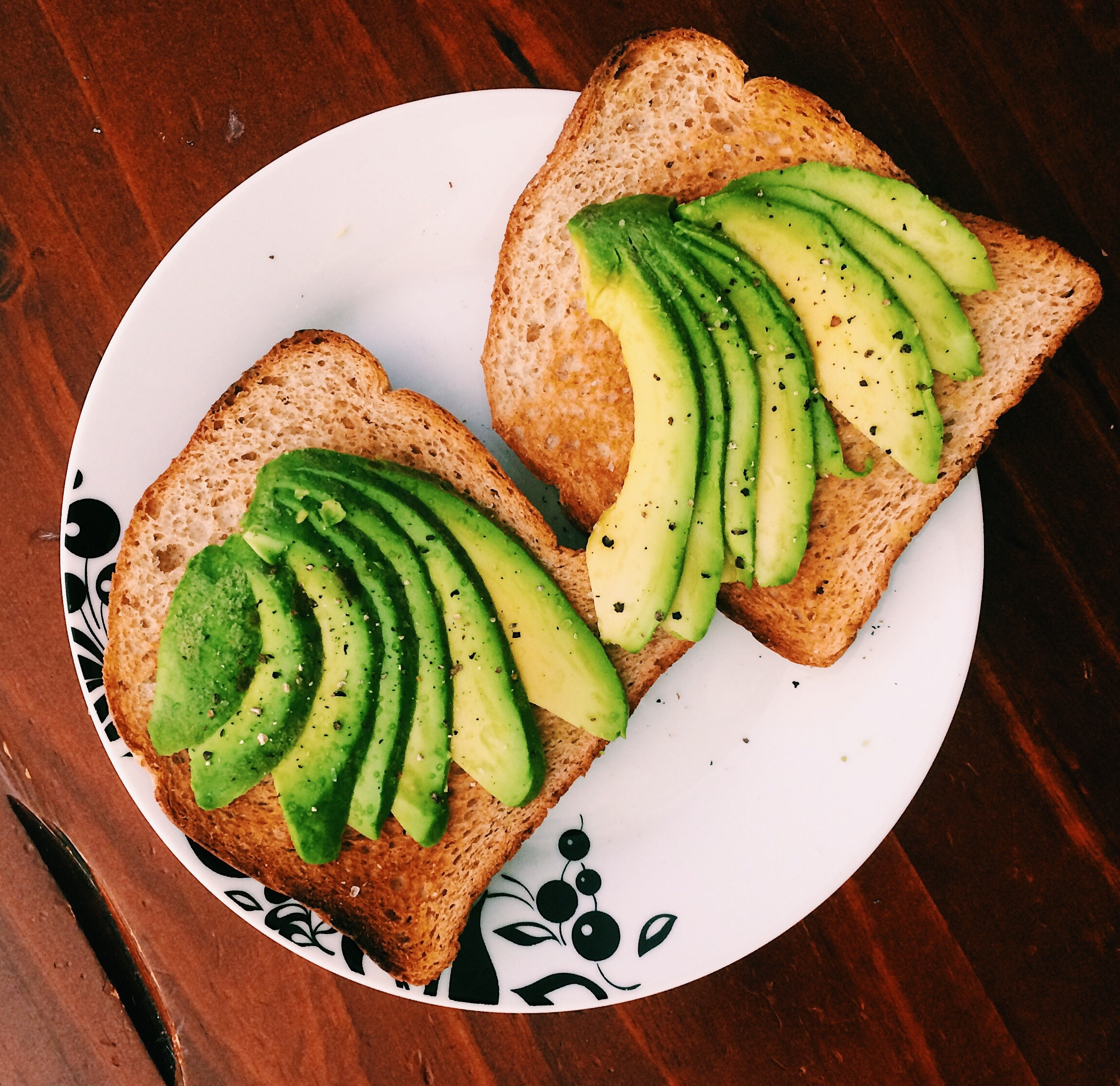 Whole wheat toast with slices of avocado on them
