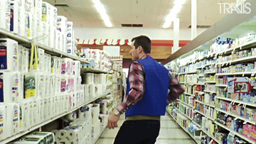 A store employee tagging items on a shelf in an aisle