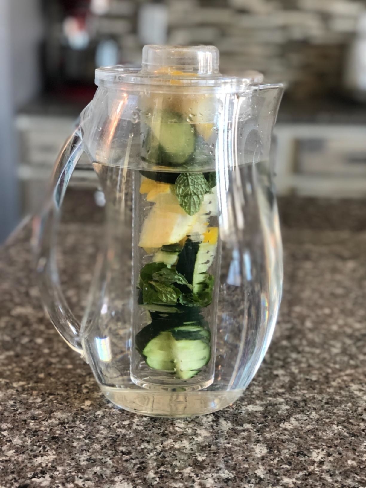 The pitcher filled with water and infused with mint, lemon, and cucumber