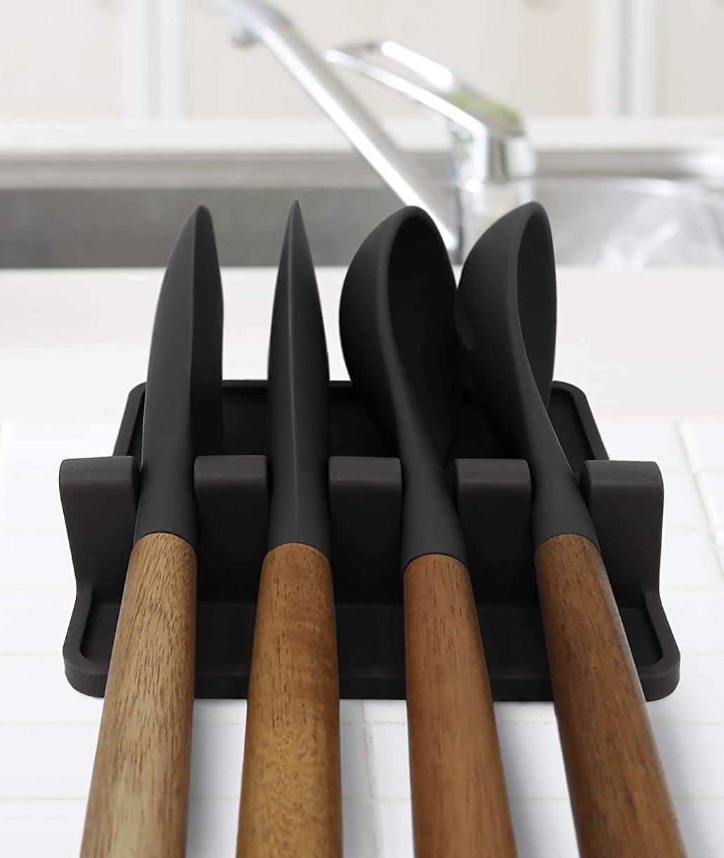 Four cooking utensils sitting in the spoon rest