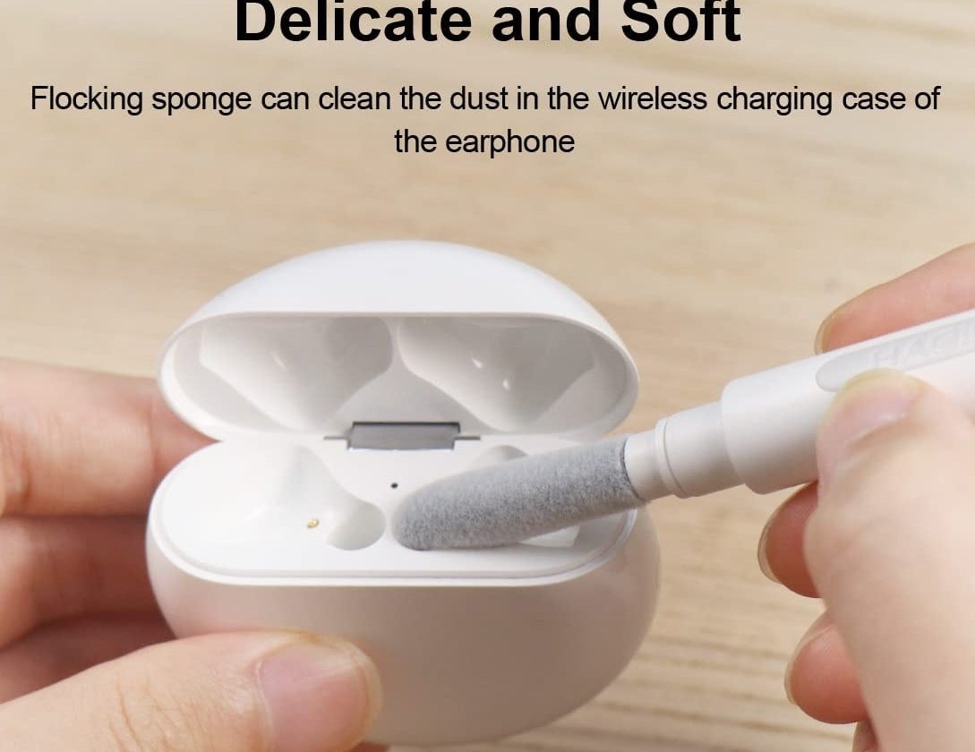 A person using the pen to clean the case of their wireless earbuds