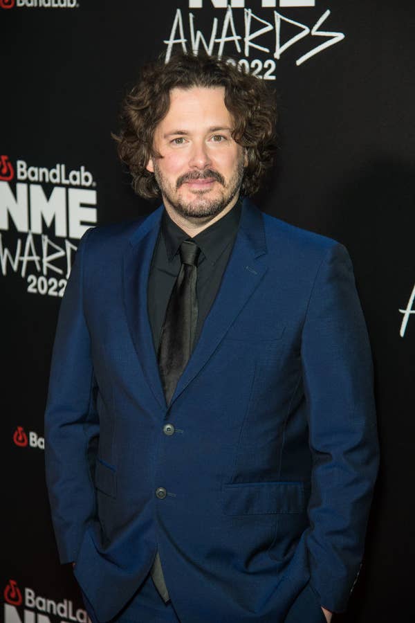 wearing a bold suit, the curly-haired director poses on the red carpet