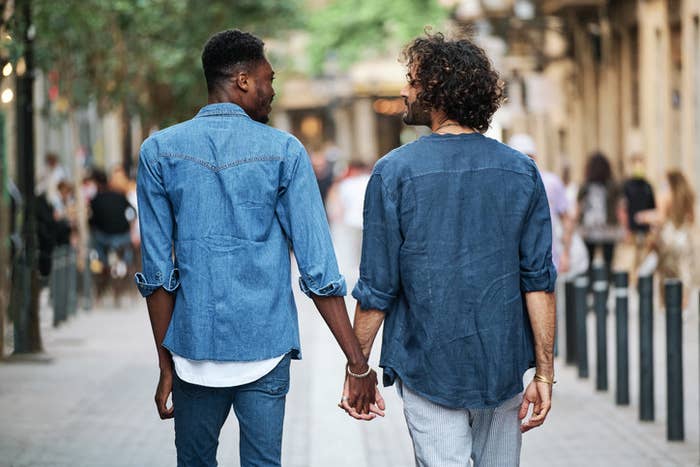 Two people holding hands and walking down the street