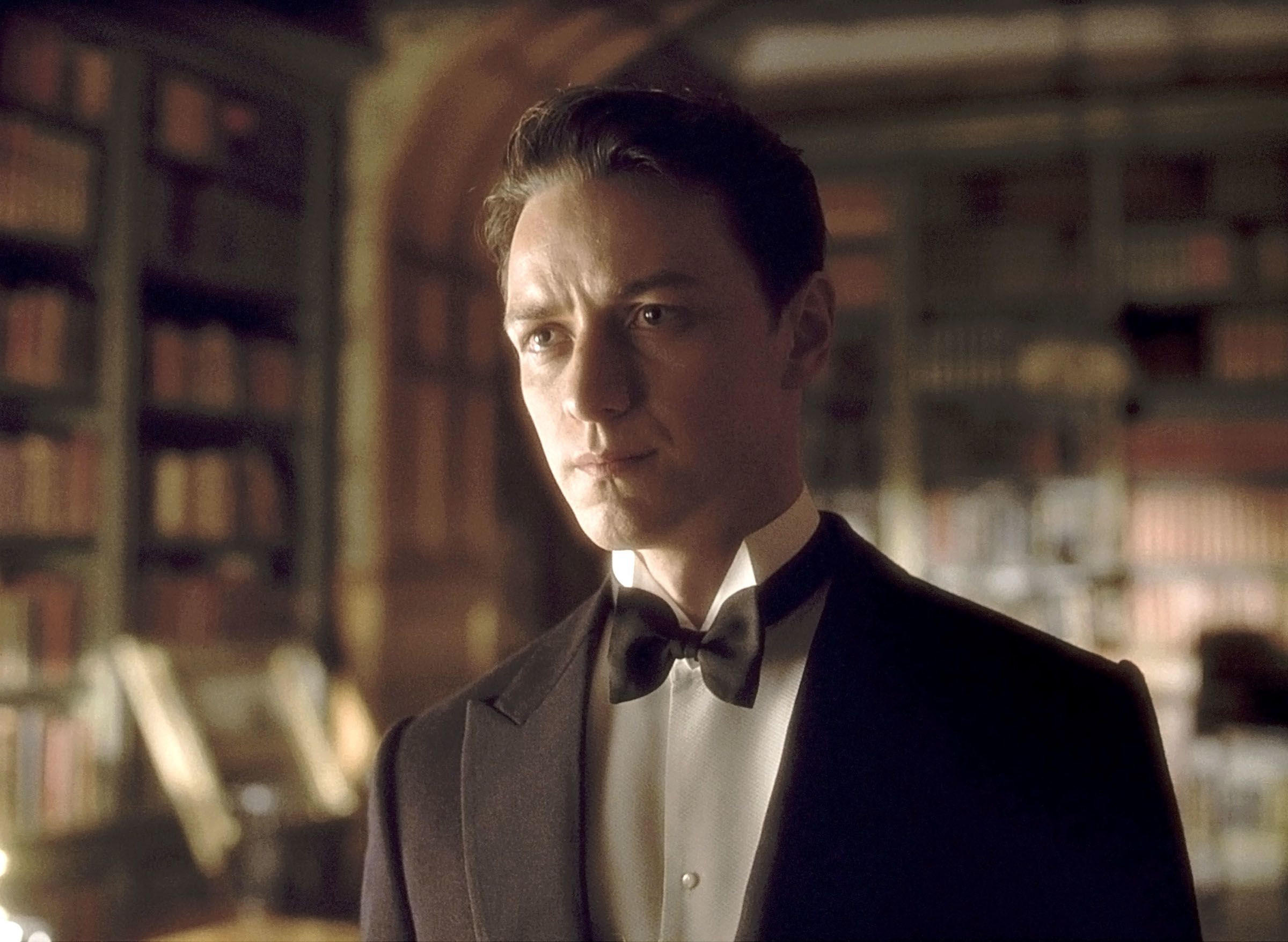 James McAvoy in a period-era tuxedo, standing in a library in a manor home