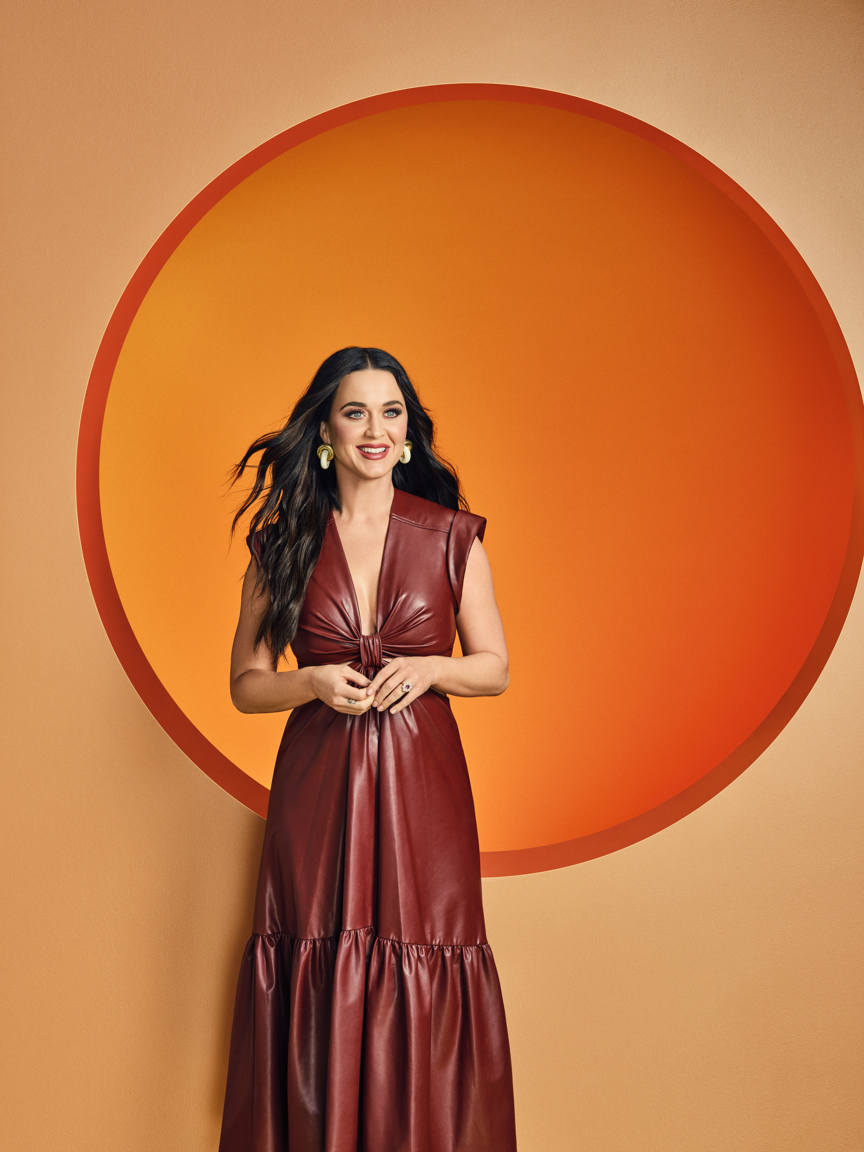 Katy poses in front of an orange circle