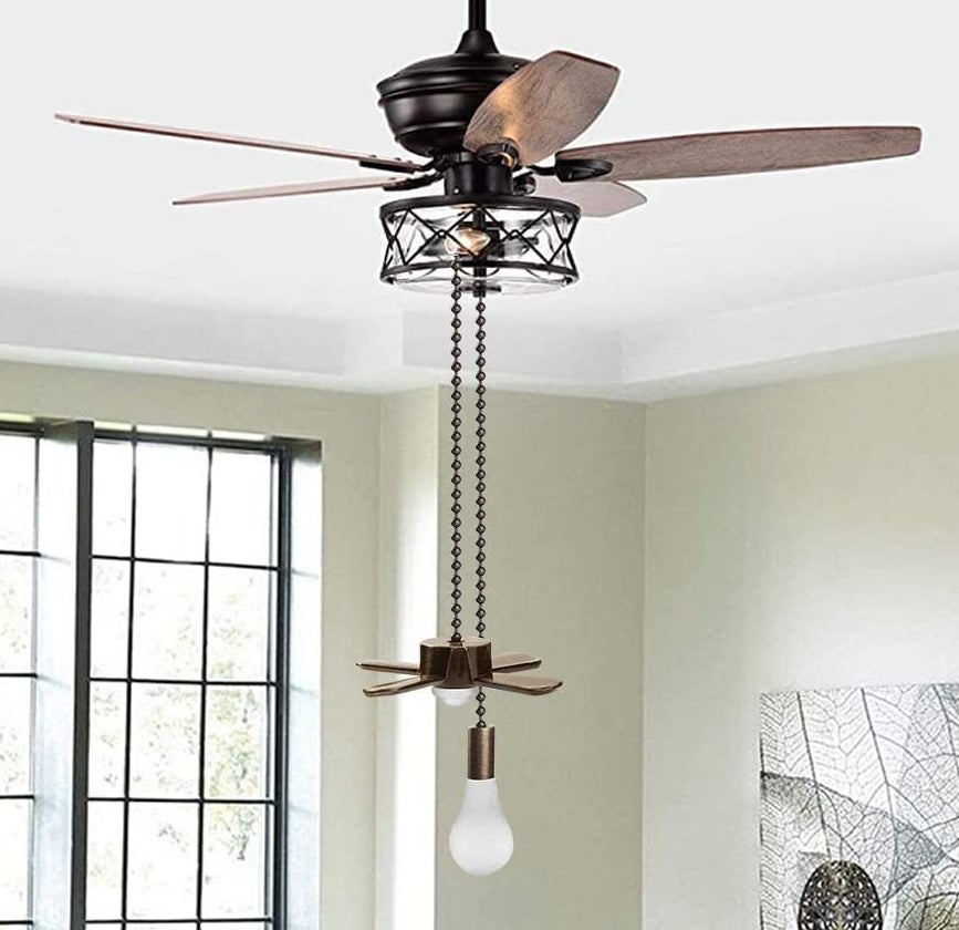 The mini fan and light pull chains hanging from a ceiling fan in a room