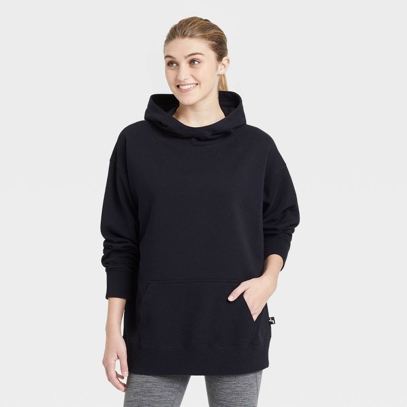Model wearing the black oversized hooded sweater