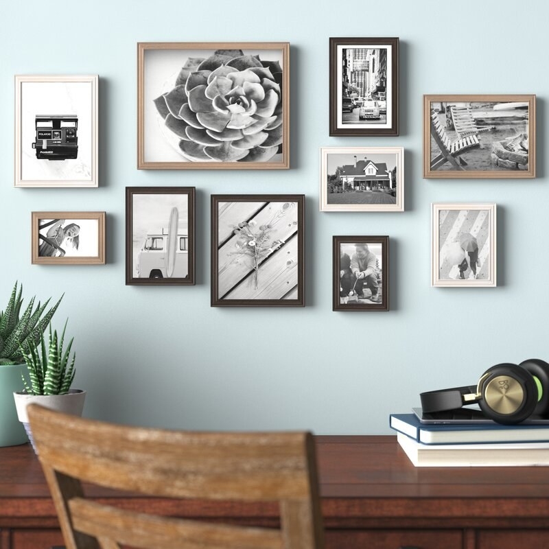 Different sized/colored frames on wall with black and white photos