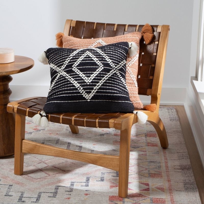 two throw pillows on a woven chair