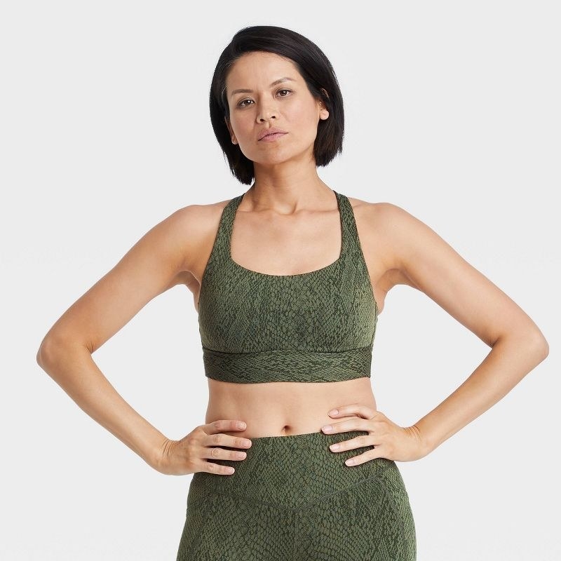 Model wearing the olive green snake print sports bra