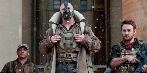 Tom Hardy as Bane in his beautiful coat standing next to two henchmen