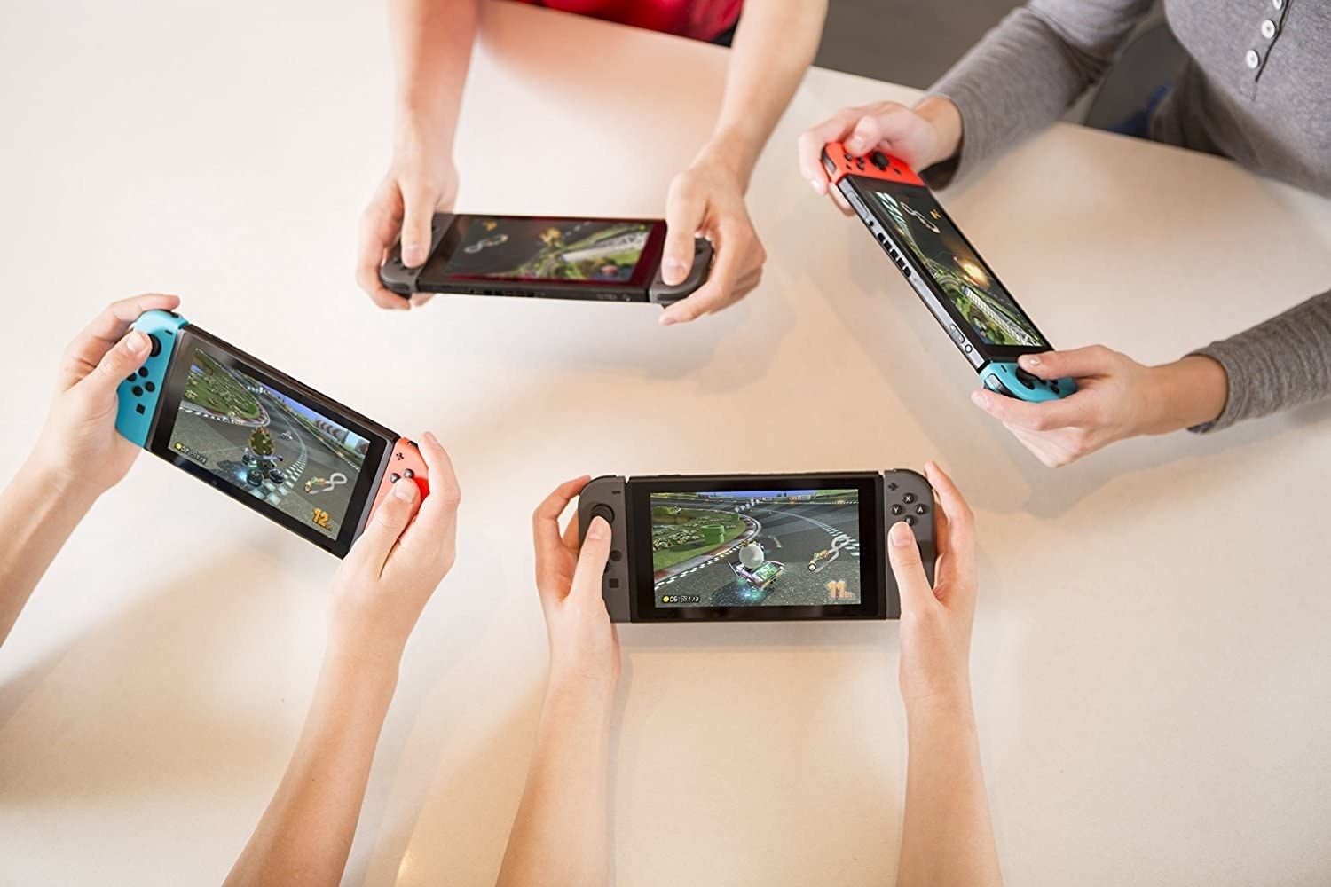 Four kids playing Mario Kart on Nintendo Switch consoles