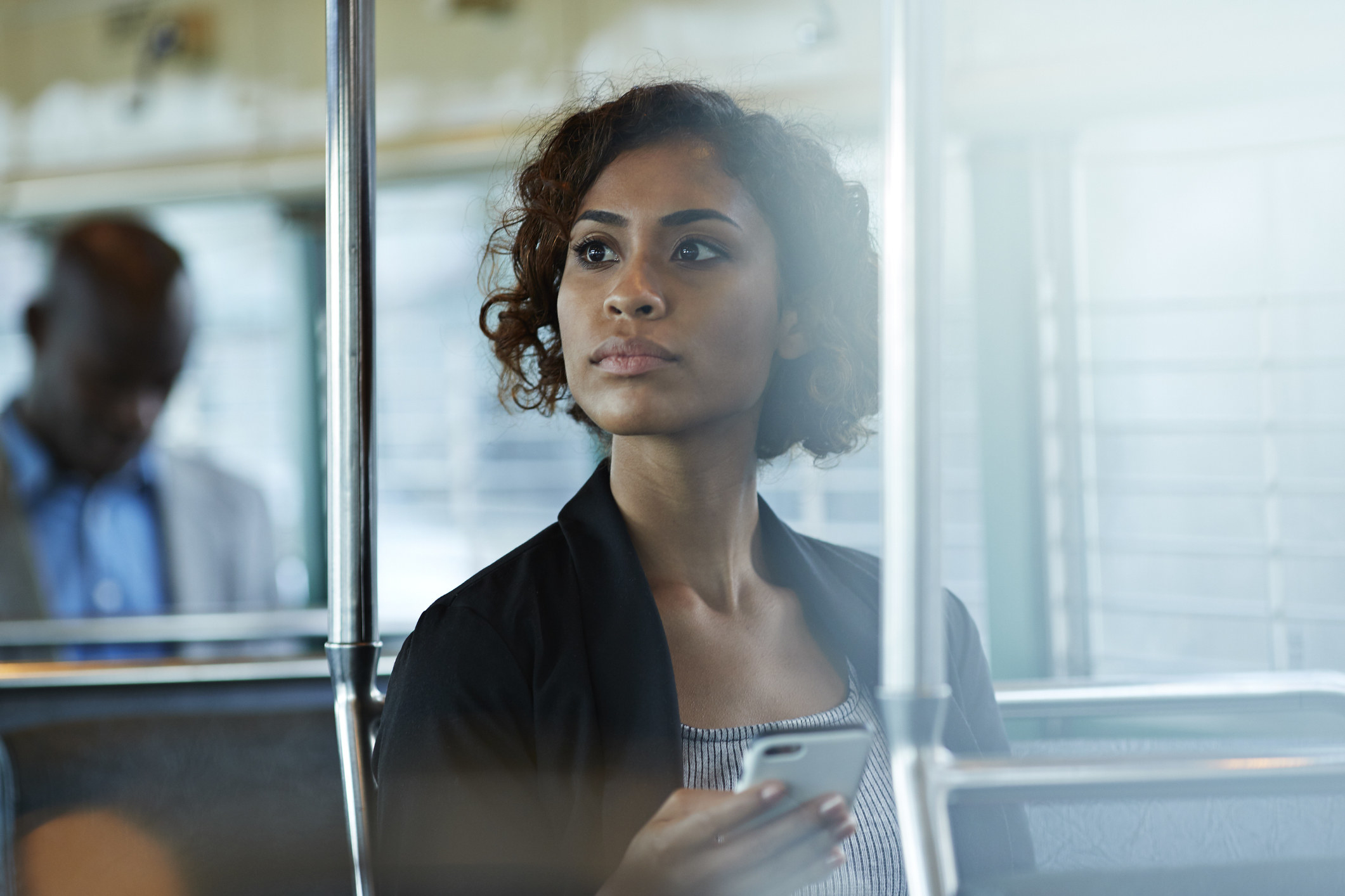 Someone looks out a window while sitting on a bus