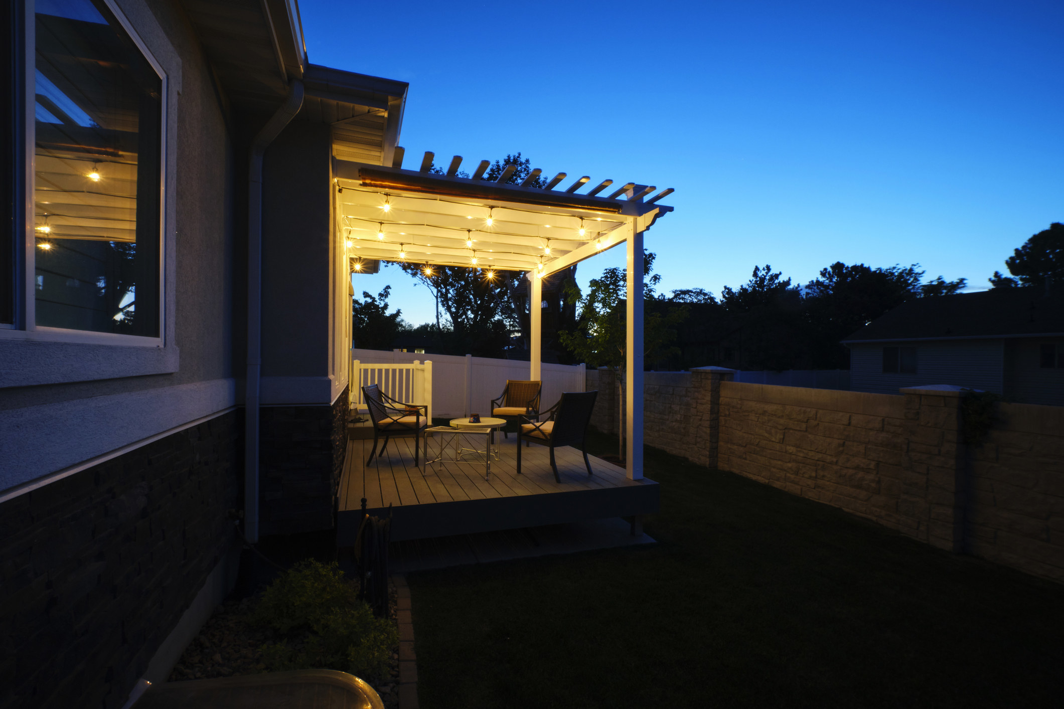 A backyard deck lit up in the evening