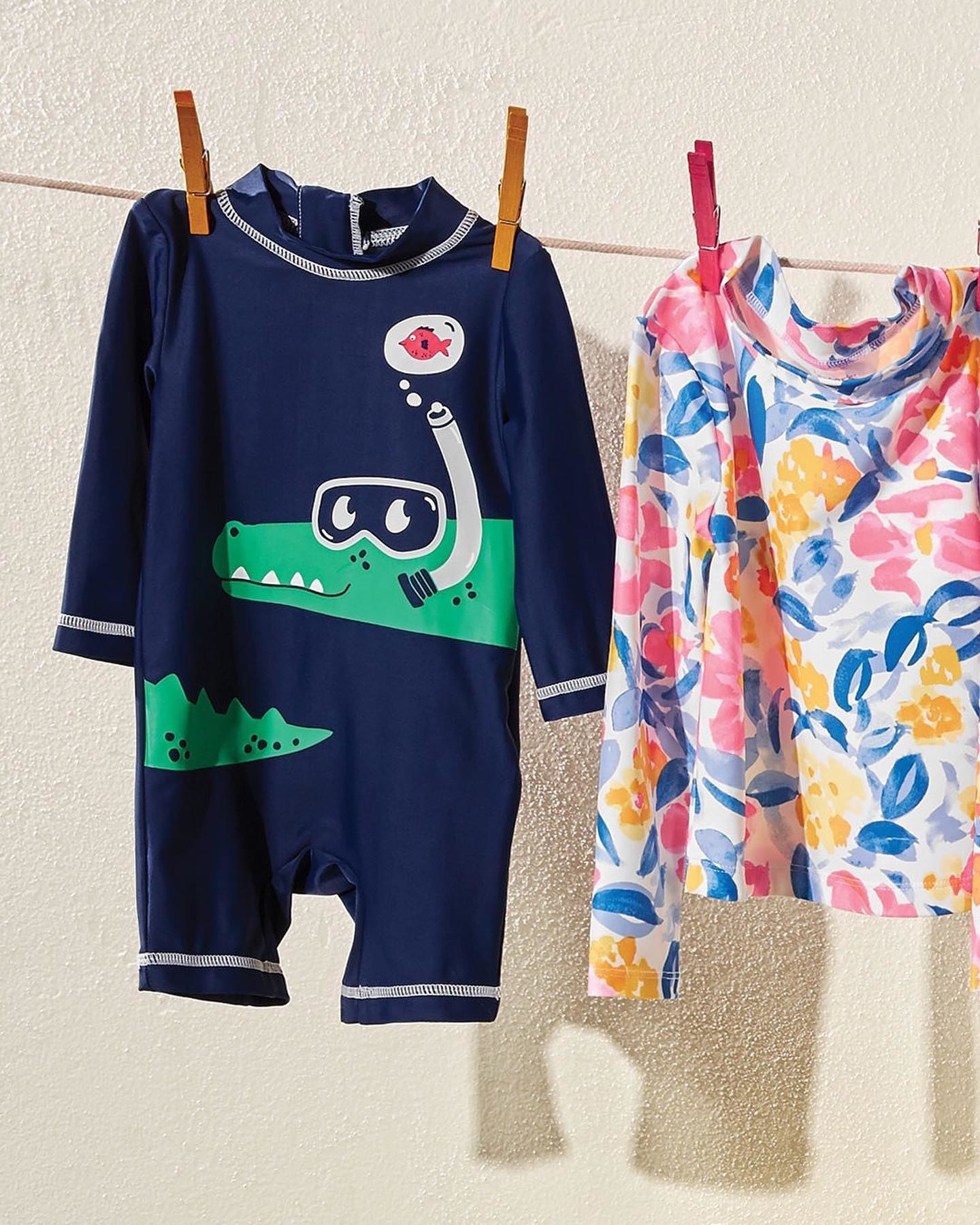 a one-piece navy blue rashguard with a scuba diving alligator on it