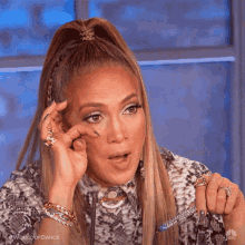 Jennifer Lopez wipes a tear from her eye