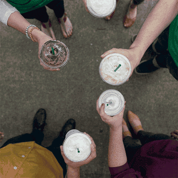 Overhead shot of people tapping each other&#x27;s iced coffee cups