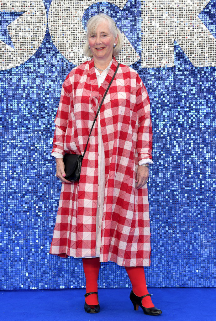 Gemma Jones wear tights and a gingham coat at an event