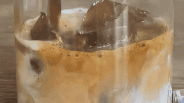 GIF of coffee being poured into a glass with ice and milk