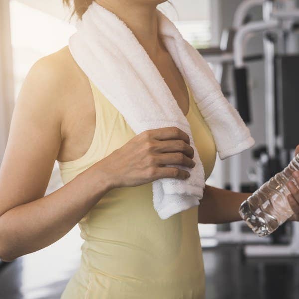 Woman in Yellow with Gym Towel Hanging around her Neck