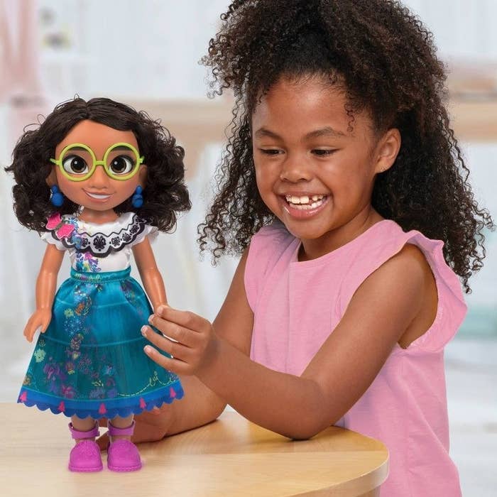 Girl playing with Mirabel doll