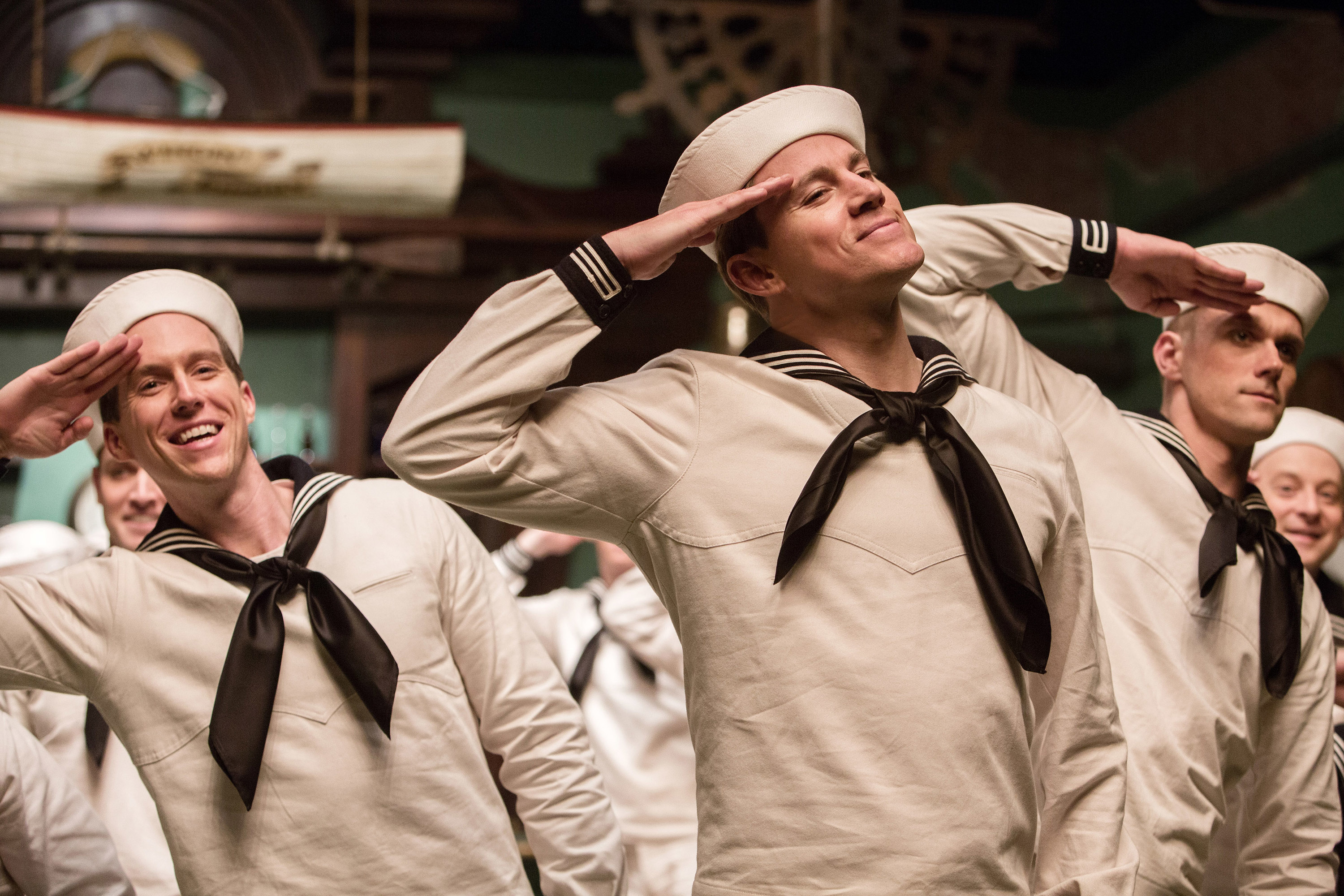 Tatum in a sailor outfit saluting with other sailors