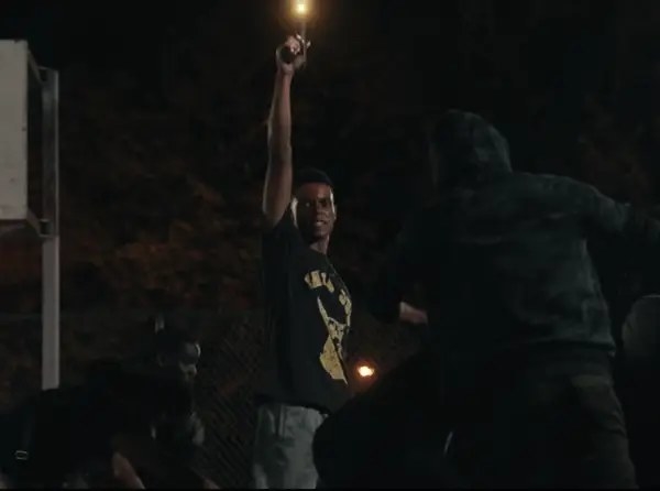 Jabari Banks as Will Smith holds a gun up in the darkness