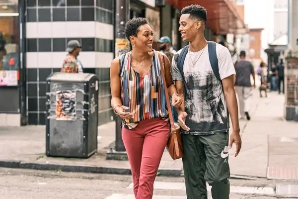 April Parker Jones as Viola &quot;Vy&quot; Smith and Jabari Banks as Will Smith cross the road together and smile in a still from &quot;Bel-Air&quot;