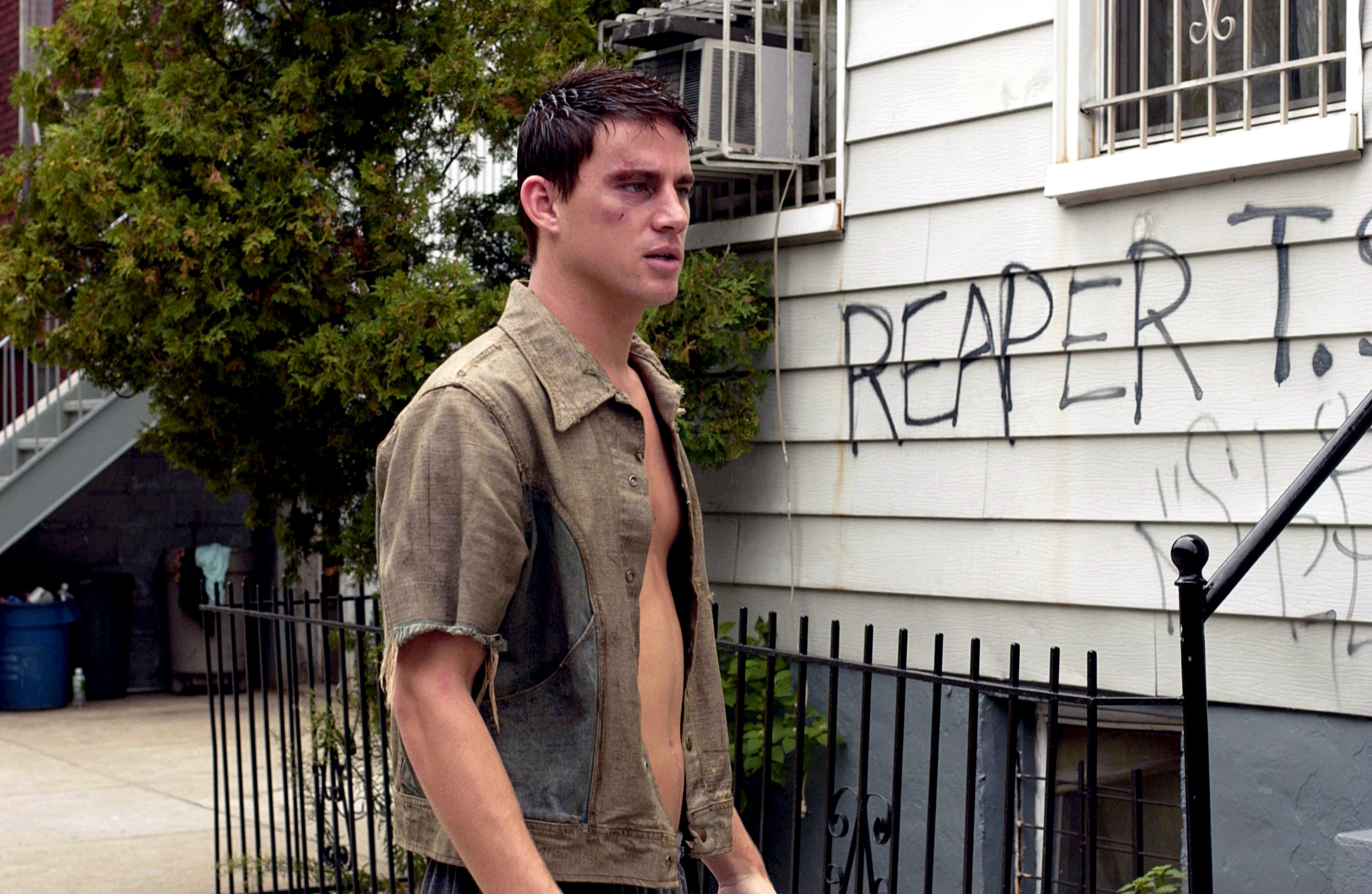 Tatum with a bruised eye outside a rundown house