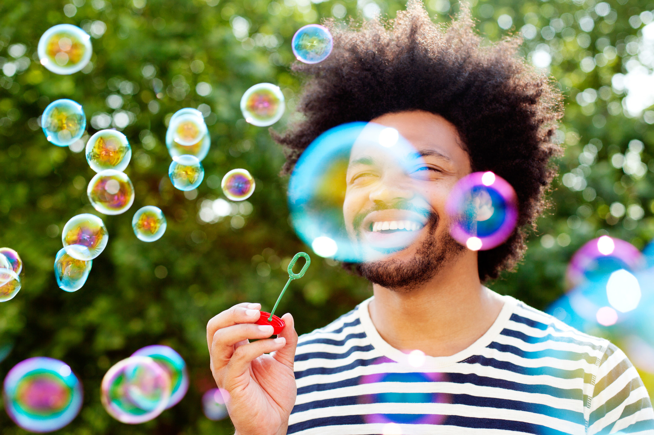 A man smiles as he is surrounded by bubbles