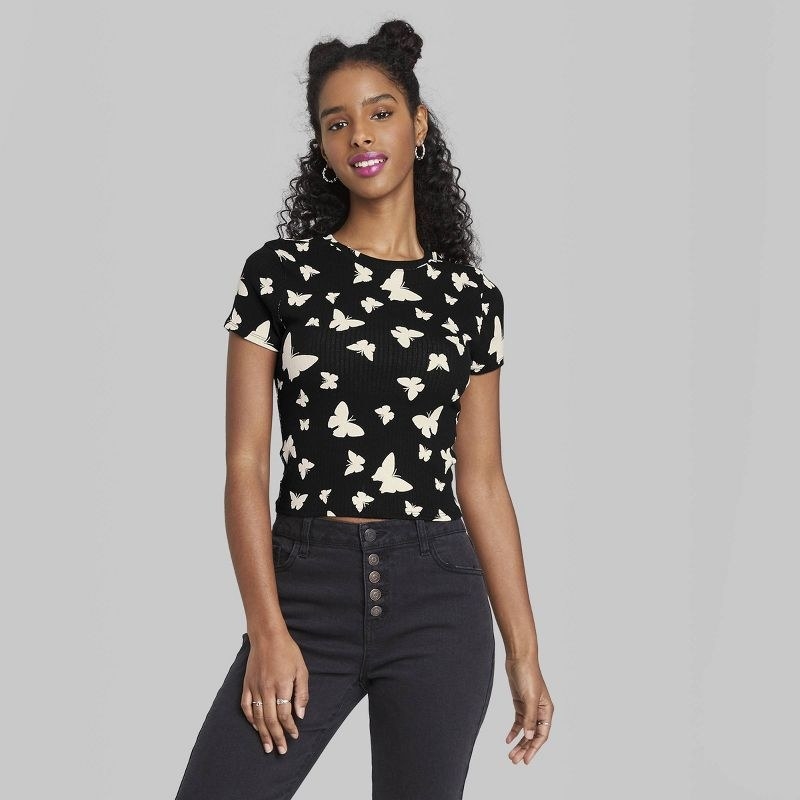 model wearing the black shirt with white butterflies on it