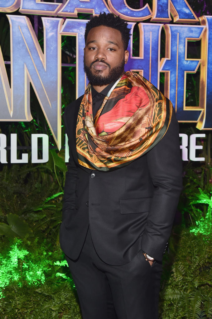 Ryan with a suit, a colorful scarf, and hands in his pants pockets at the Los Angeles world premiere of &quot;Black Panther&quot;