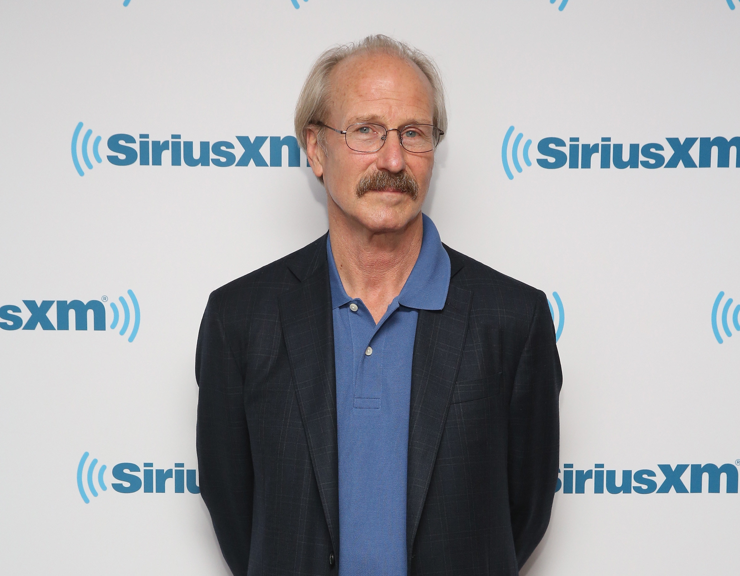 William Hurt poses at a step-and-repeat