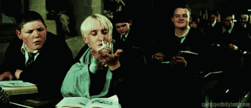 Draco Malfoy releasing a paper bird into the air