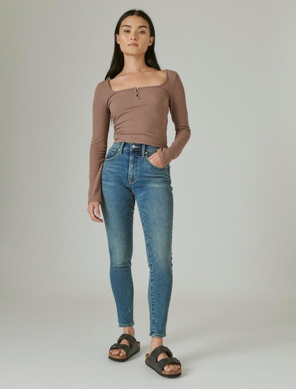 model wearing a brown top and high-rise jeans